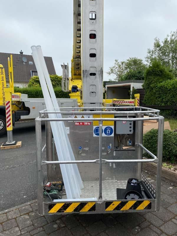 Ein gelber Lastwagen mit einer Leiter auf der Rückseite