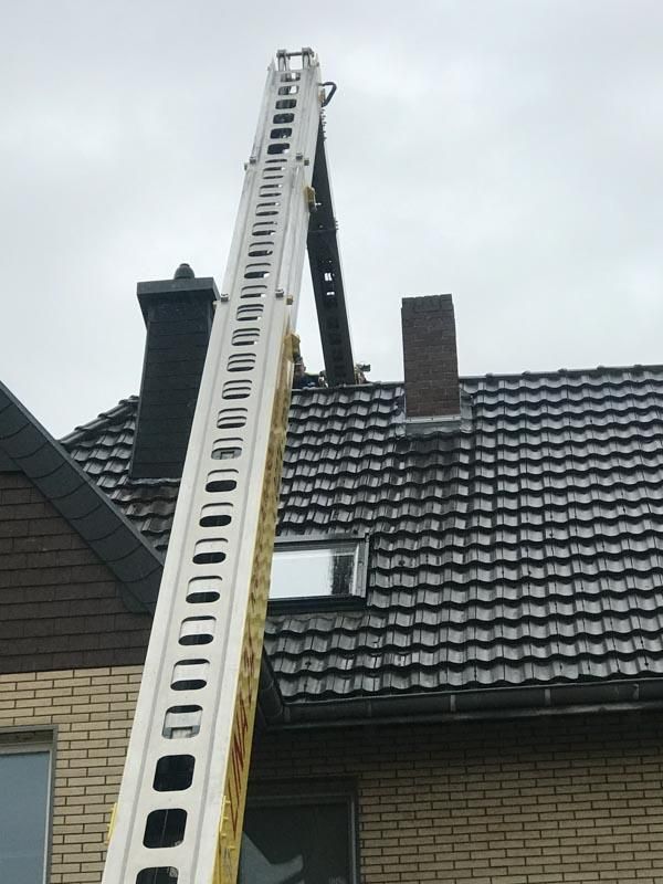 Eine Leiter ist am Dach eines Hauses befestigt