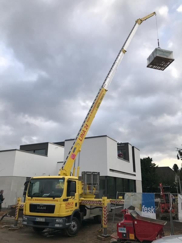 Ein gelber LKW mit einem daran befestigten Kran