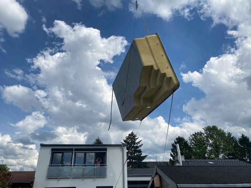 Ein großer Block wird von einem Kran in die Luft gehoben