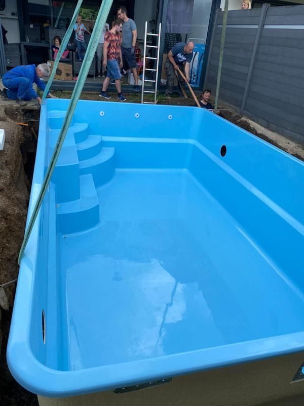 In einem Hinterhof wird ein blauer Swimmingpool gebaut