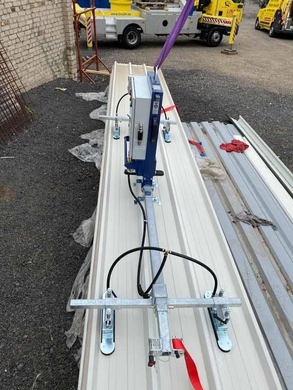 Auf einem weißen Dach steht eine Maschine.