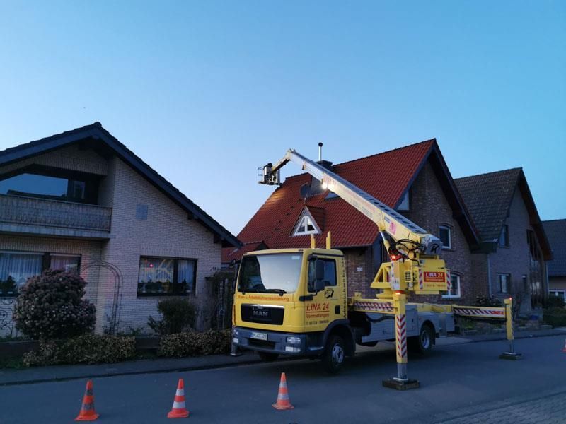 Ein gelber Lastwagen steht vor einem Haus