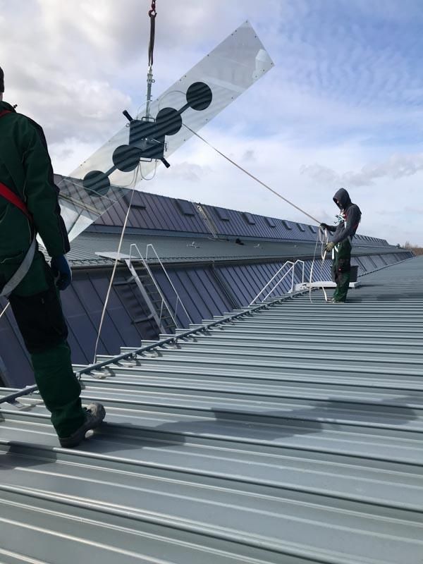 Zwei Männer arbeiten auf dem Dach eines Gebäudes