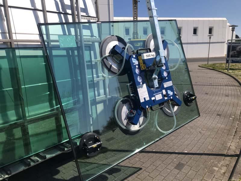 Ein großes Stück Glas wird von einer Maschine angehoben.