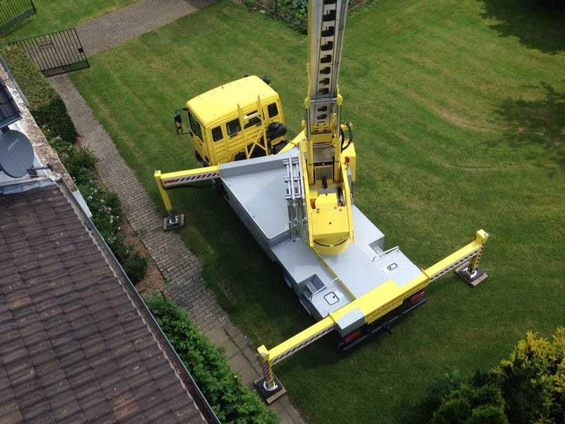 Eine Luftaufnahme eines gelben LKWs mit einem daran befestigten Kran