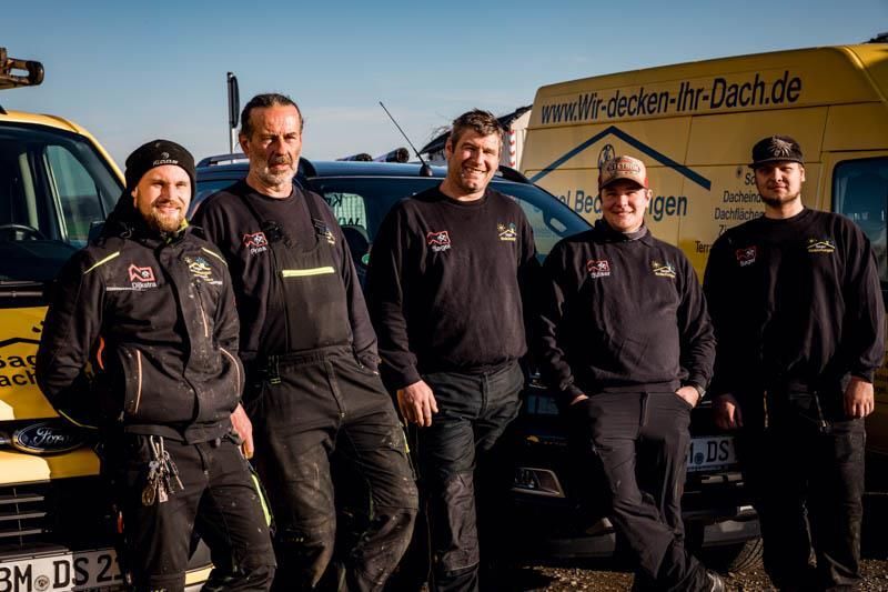 Eine Gruppe Männer posiert vor einem Lieferwagen für ein Foto.