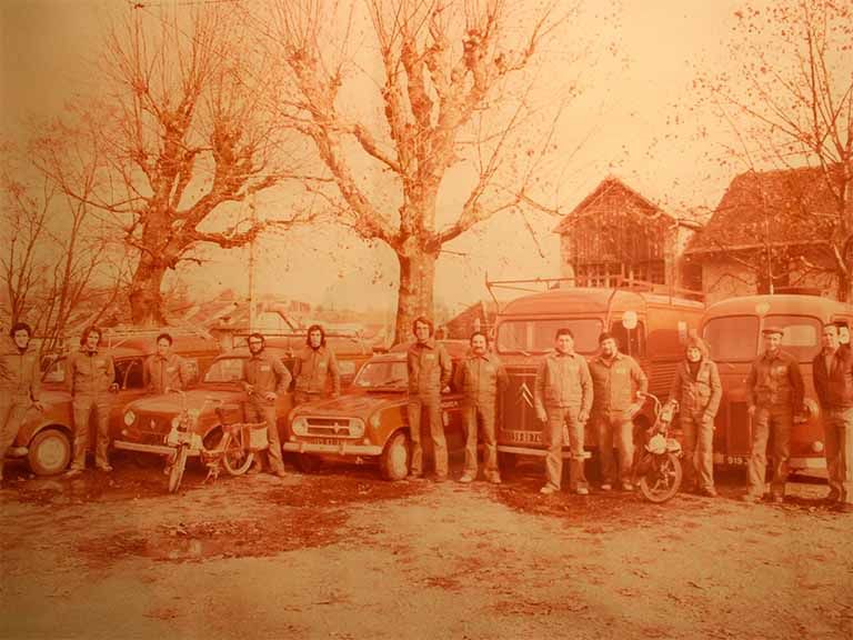 Des hommes et des voitures sur une photo avec un filtre sepia