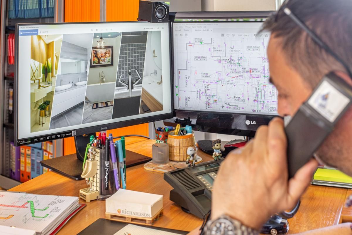 Un homme au téléphone devant deux écrans