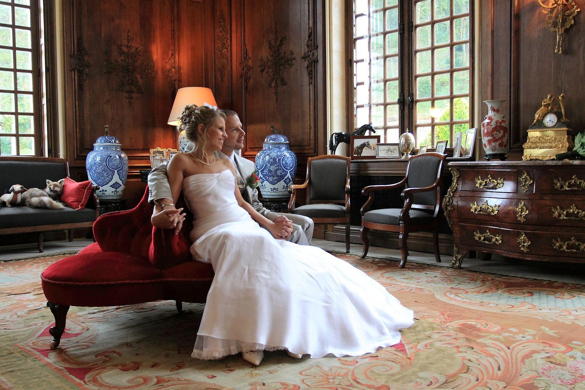 Couple de mariés sur un canapé rouge