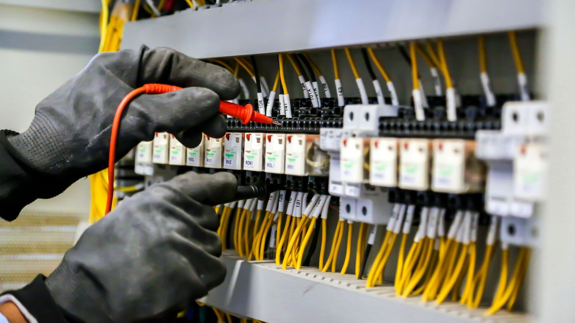 Vérification du tableau électrique avec des gants