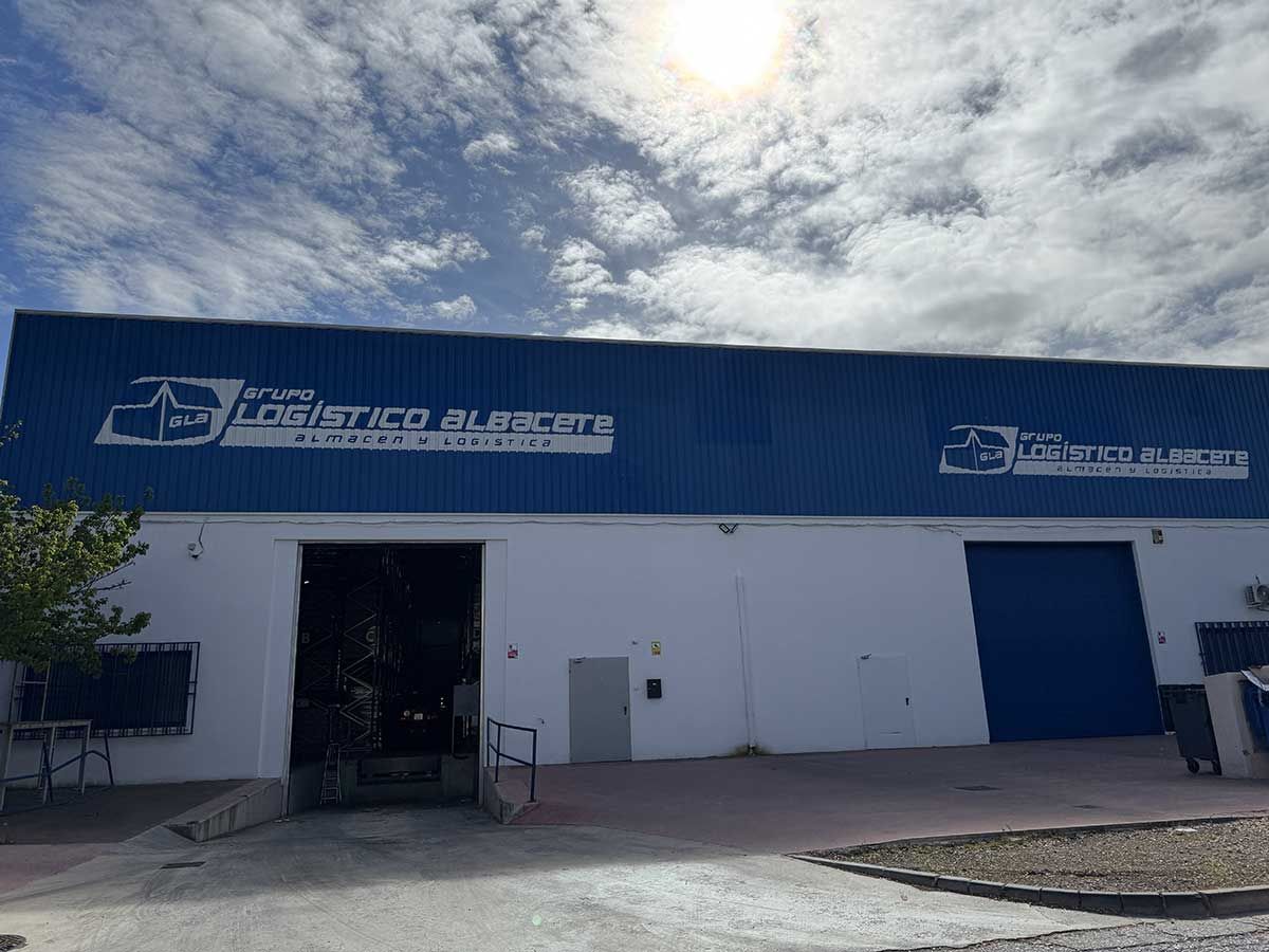 Un gran edificio blanco con un techo azul y una puerta azul.