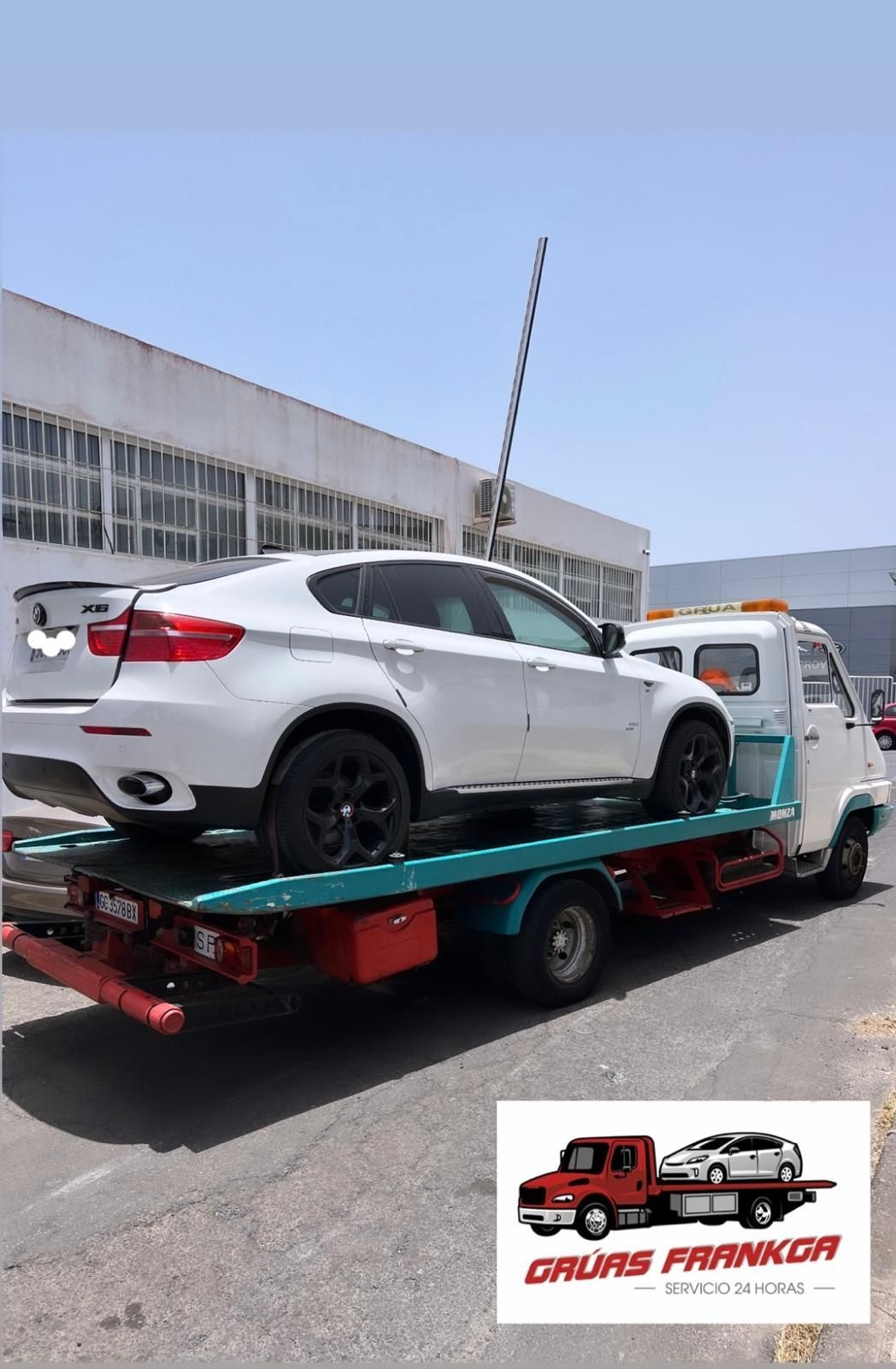 Un coche blanco está siendo remolcado por una grúa.