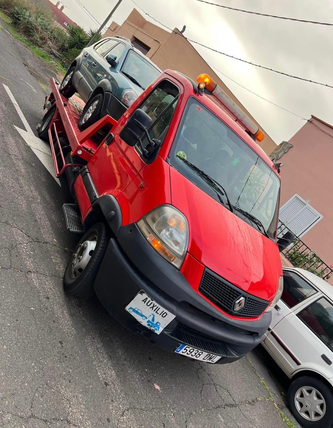 Una grúa roja está estacionada al costado de la carretera
