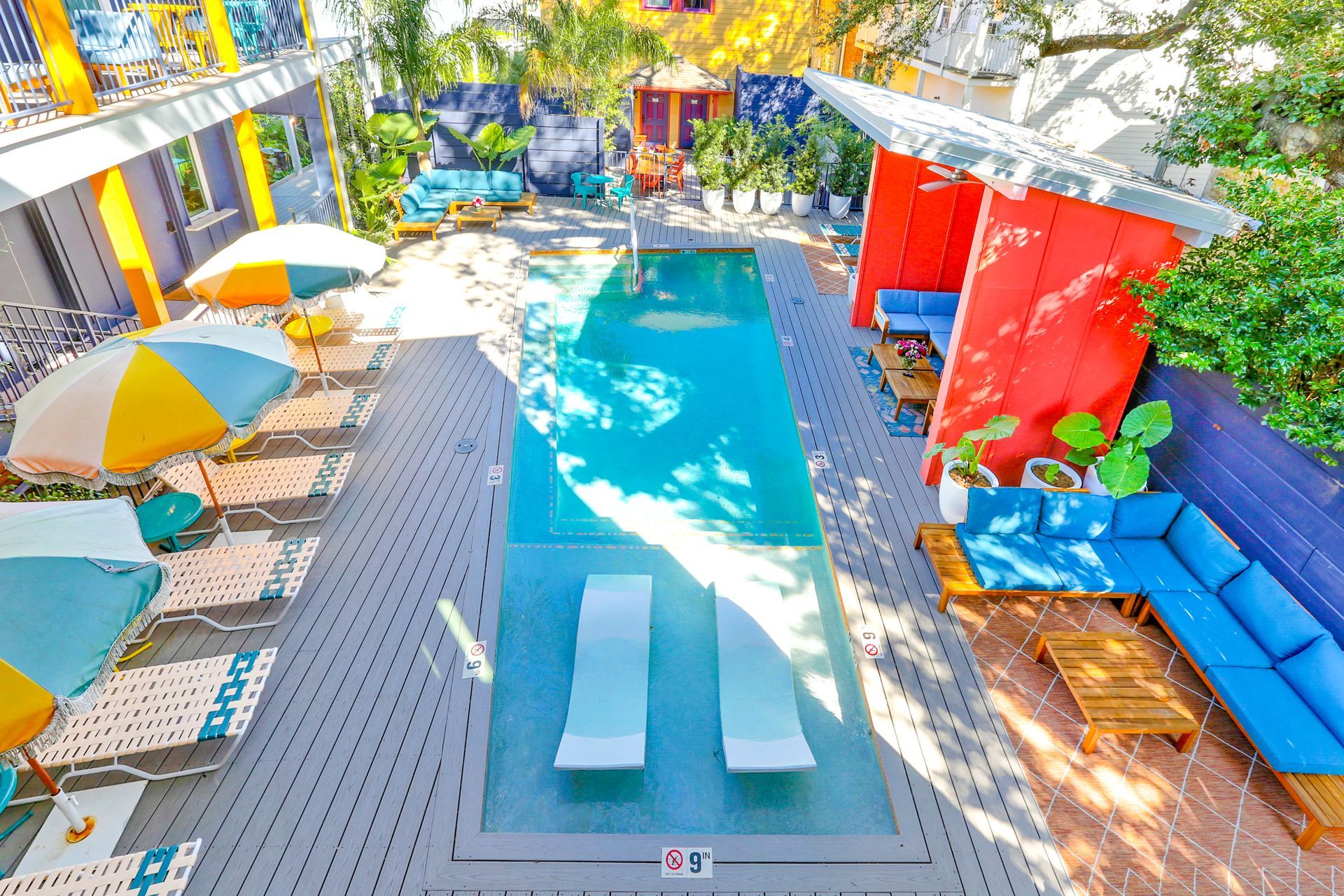 An aerial view of a swimming pool surrounded by chairs and umbrellas.