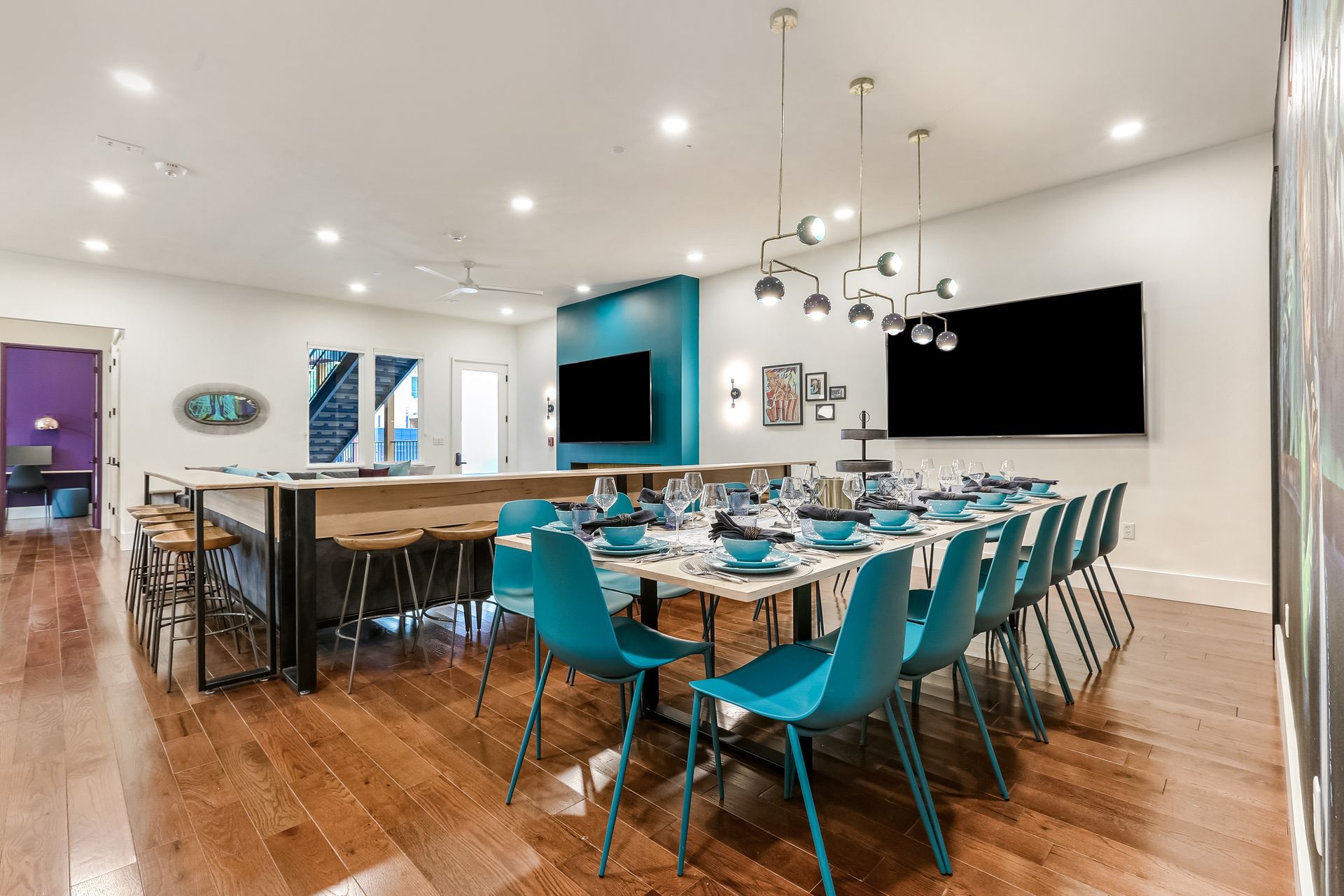 A large dining room with tables and chairs and a flat screen tv.