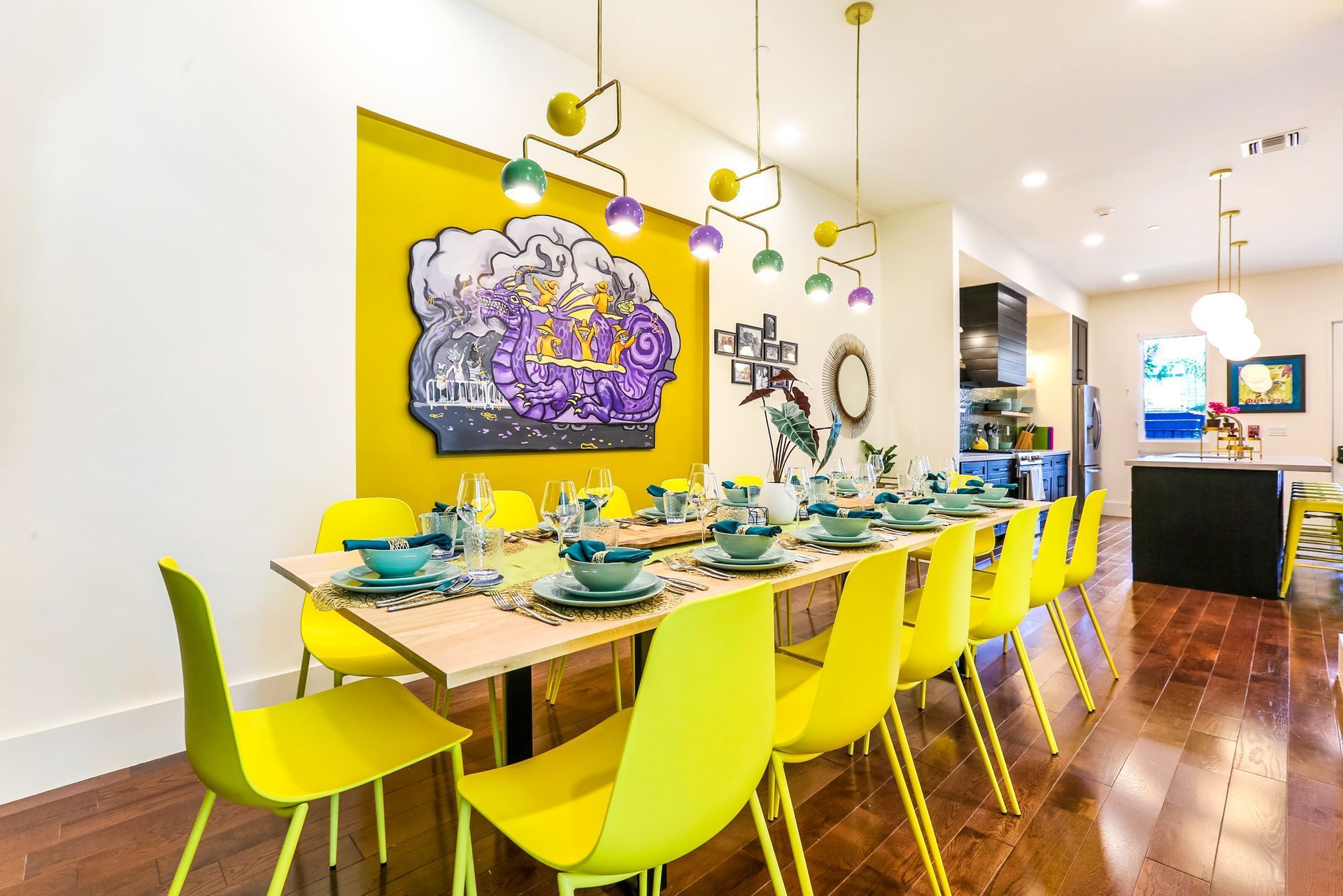 A dining room with a long table and yellow chairs.