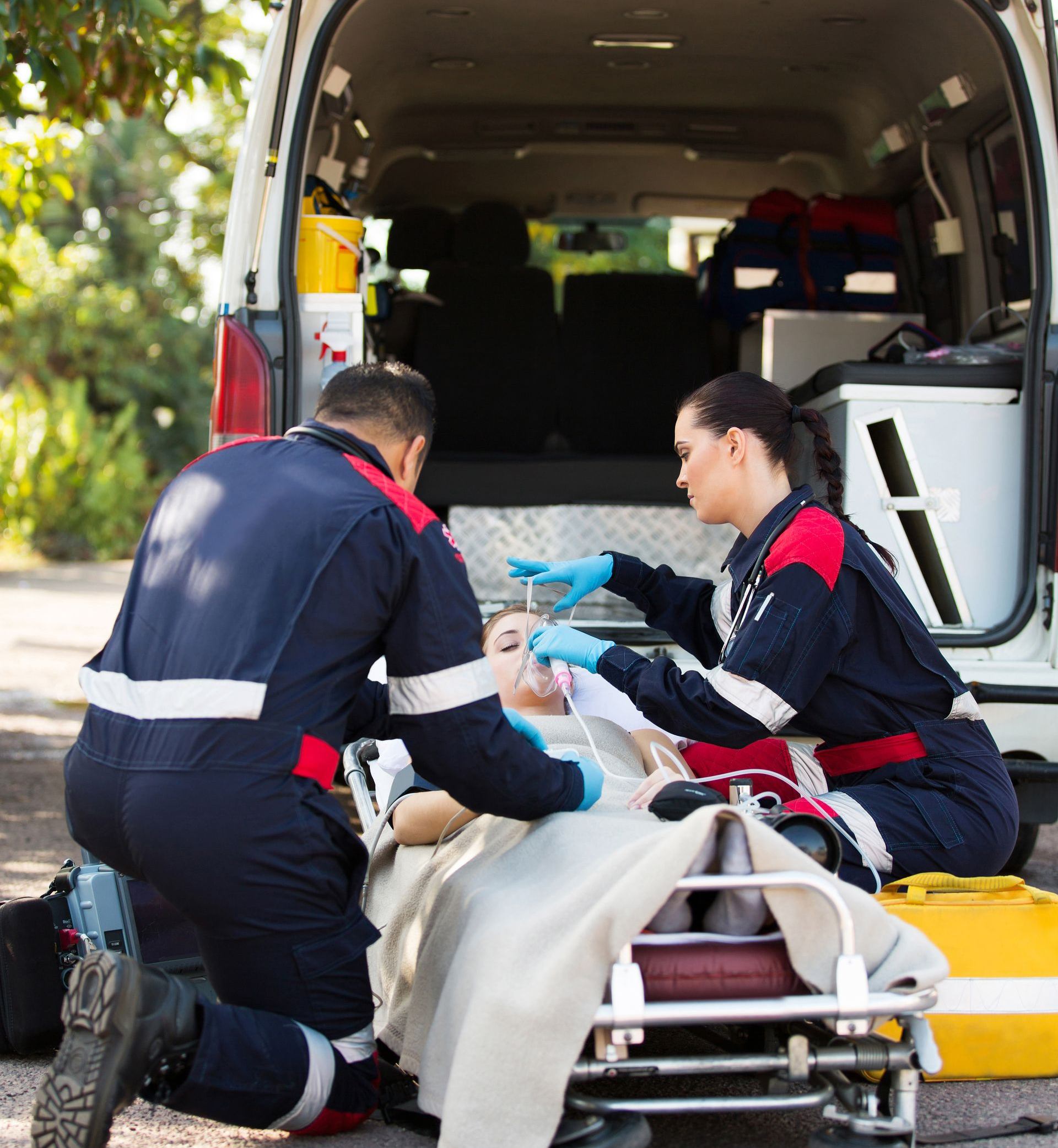 Des secouristes soignent une personne sur une civière près d'une ambulance.