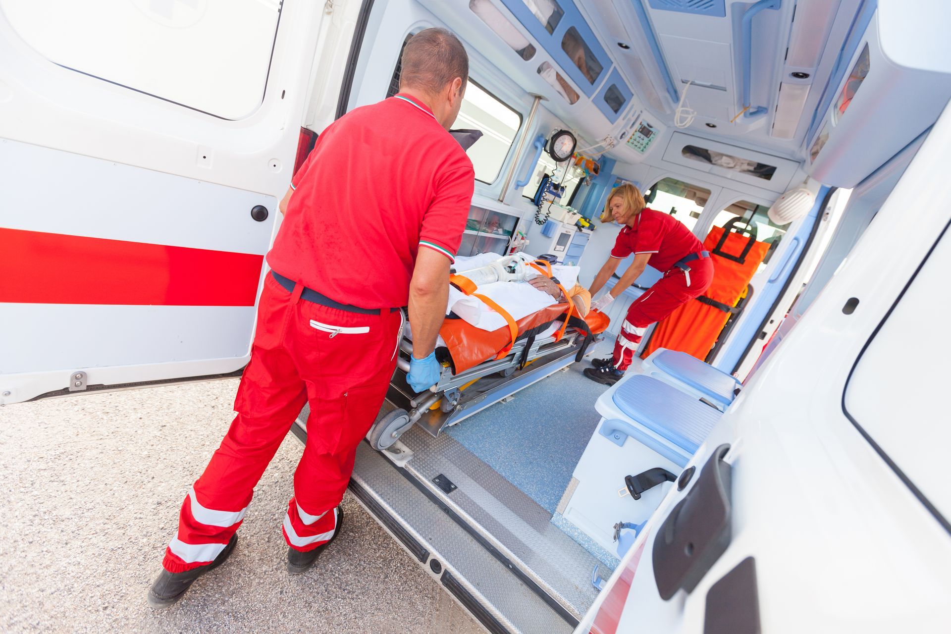 Des ambulanciers chargent un patient dans une ambulance.