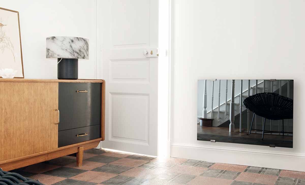 Salon avec une armoire en bois vintage, une lampe en marbre et un radiateur mural miroir.