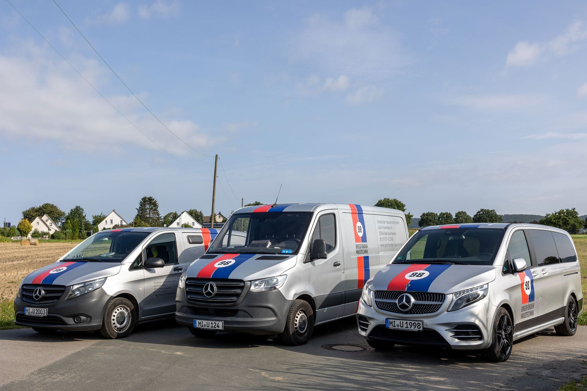 Eine Gruppe von Menschen posiert vor ihren Lieferwagen für ein Foto.