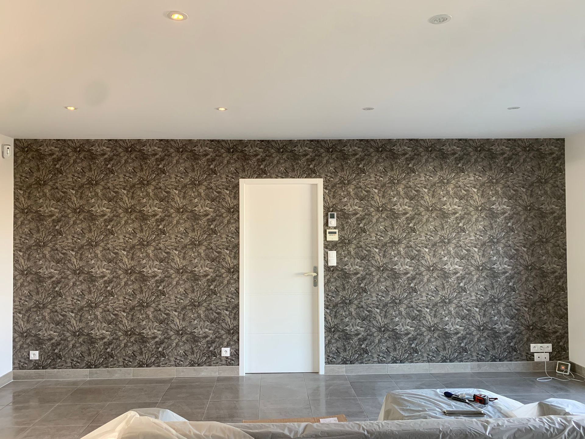 Papier peint gris avec des motifs sur un mur