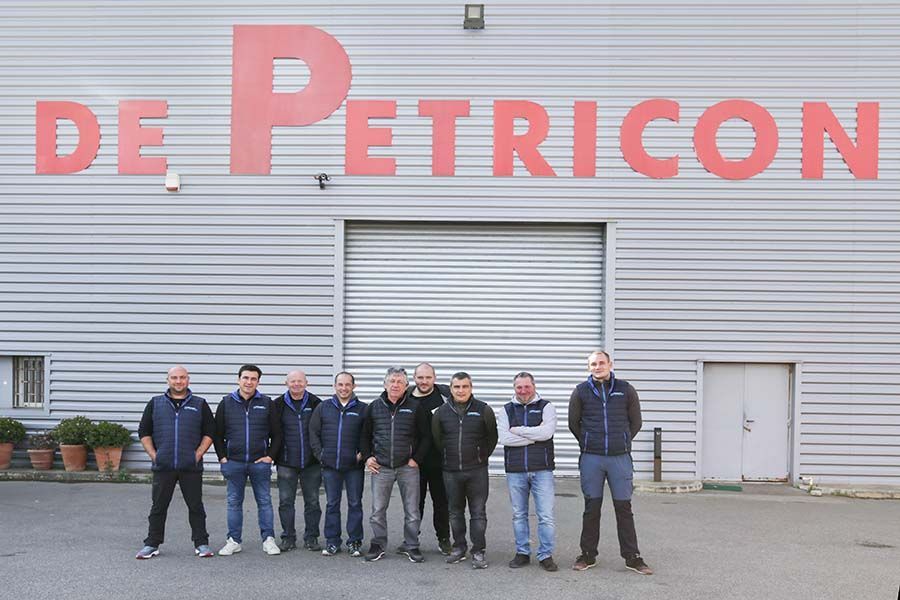 Équipe De Petriconi devant un hangar
