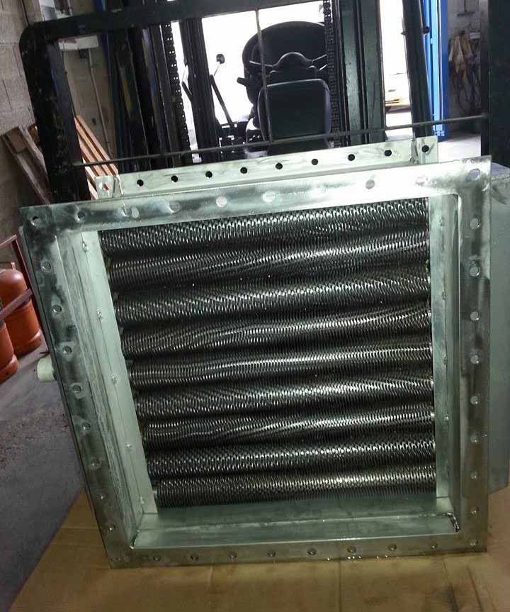 Un calentador de metal está colocado sobre un piso de madera al lado de una carretilla elevadora.