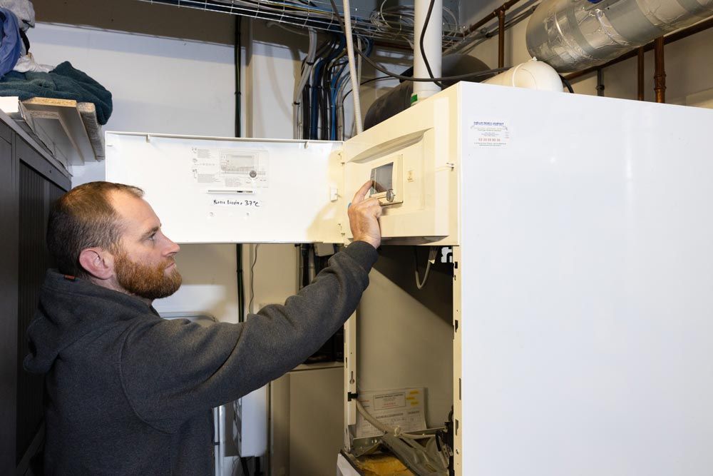 Ouvrier réglant le thermostat d’une chaudière