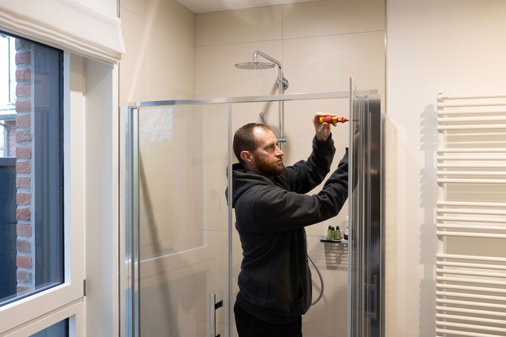 Ouvrier qui remplace une porte de douche