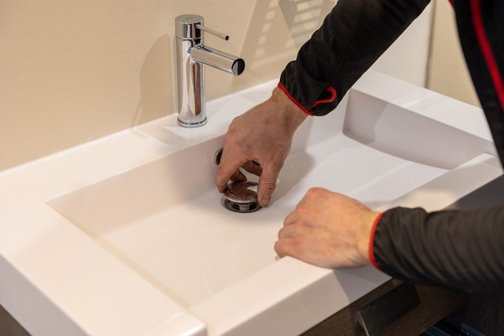 Ouvrier retirant la bonde d’un lavabo