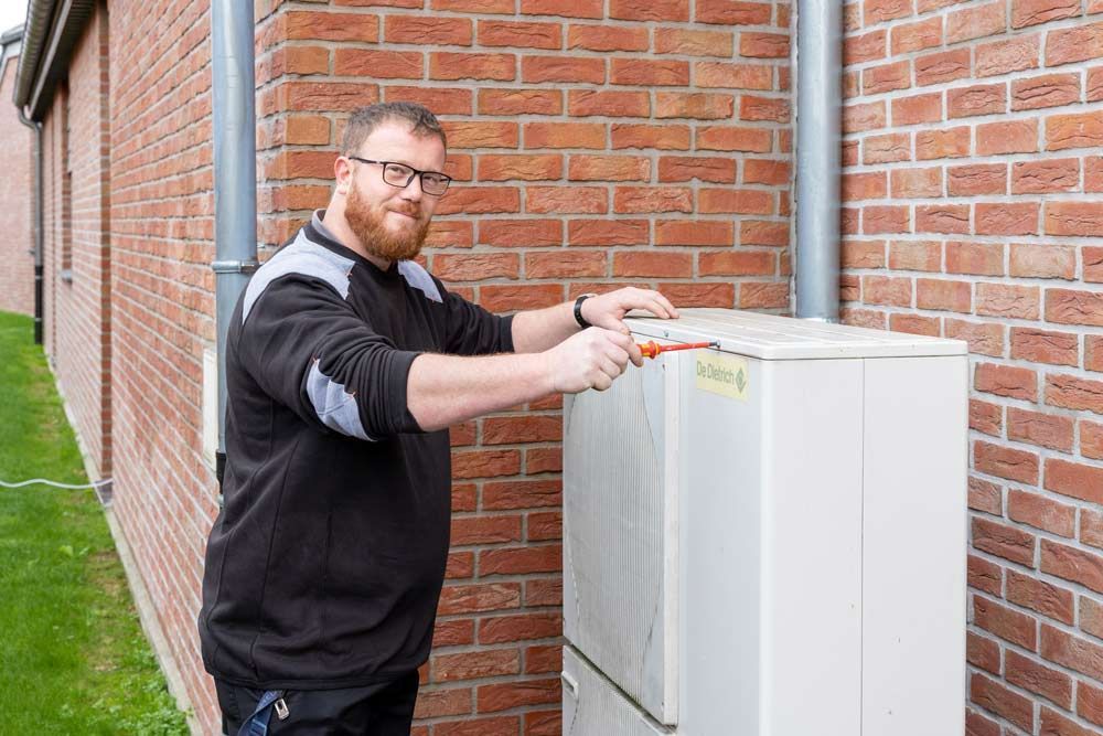 Ouvrier qui travaille sur une pompe à chaleur