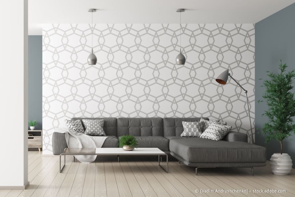 Modernes Wohnzimmer mit grauem Ecksofa, gemusterter Akzentwand und Holzboden.