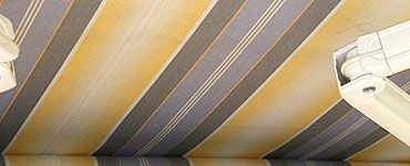 Store rayé jaune et gris avec quincaillerie blanche.