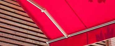 Auvent rouge au-dessus de lattes de bois.