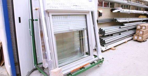 Fenêtre blanche avec volet intégré sur un chariot vert dans un magasin.