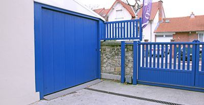 Porte de garage bleue et clôture assortie.