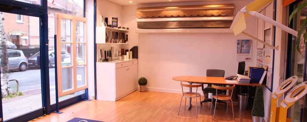 Intérieur d'un bureau avec une porte ouverte, une table et des chaises, et un petit comptoir.