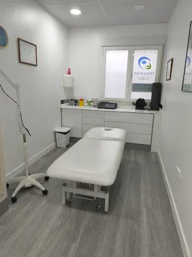 Una sala de exploración médica limpia y blanca con una camilla central