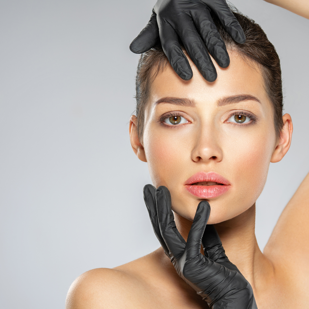 Eine Frau mit schwarzen Handschuhen berührt ihr Gesicht.