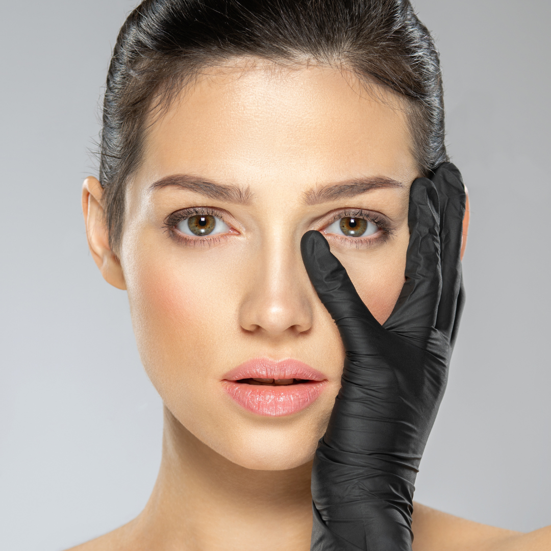 Eine Frau mit schwarzen Handschuhen bedeckt ihr Gesicht mit der Hand.
