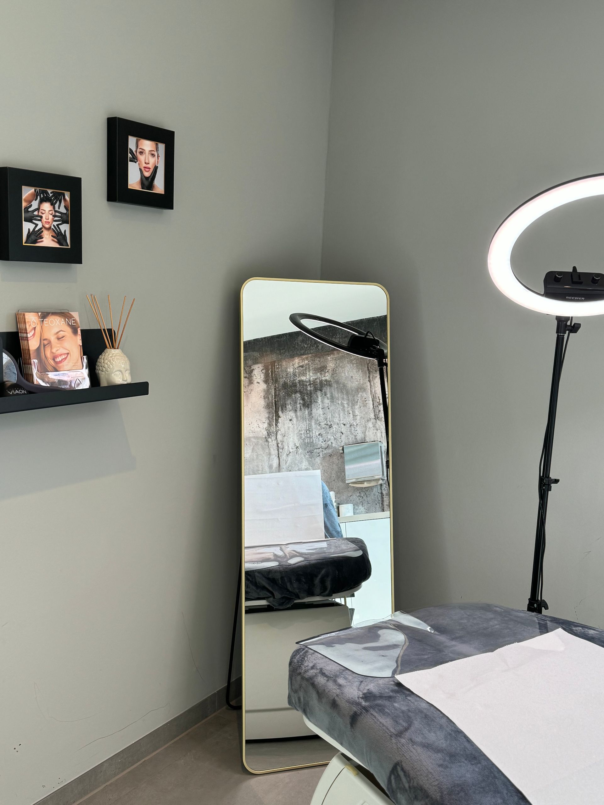 Ein Zimmer mit Bett, Spiegel, Lampe und Bildern an der Wand.