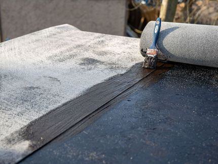 Application d'une peinture de toiture noire au pinceau