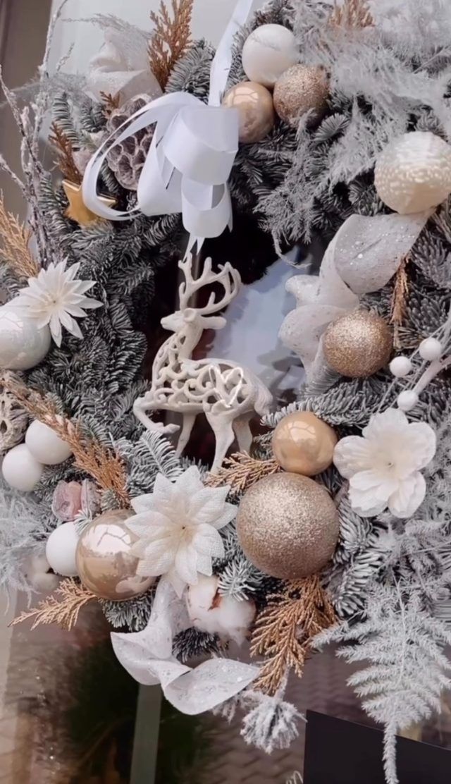 Eine Nahaufnahme eines Weihnachtskranzes mit einem Hirsch und Kugeln darauf.