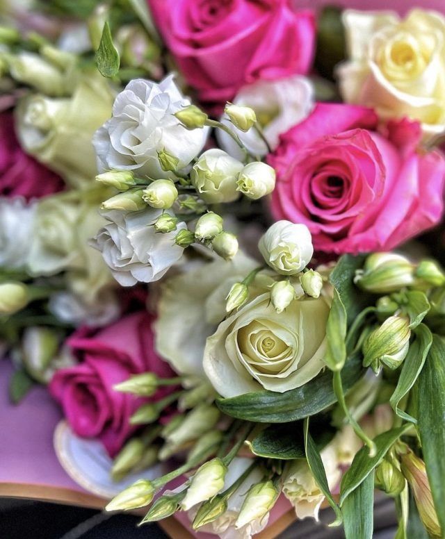 Eine Nahaufnahme eines Straußes rosa und weißer Rosen.