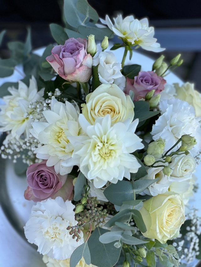 Eine Nahaufnahme eines Kuchens mit Blumen darauf auf einem Tisch.