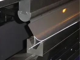 Tôle pliée par une presse plieuse industrielle, formant un coin.