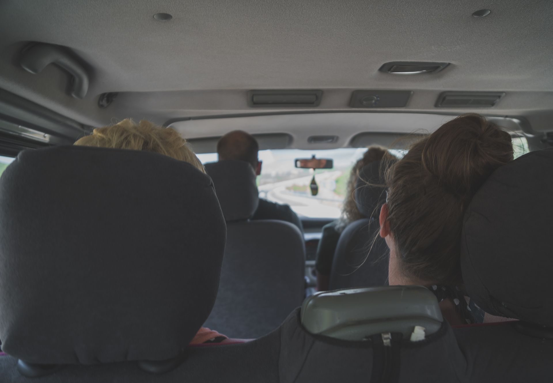 Plusieurs personnes assises vue de l'arrière d'un véhicule