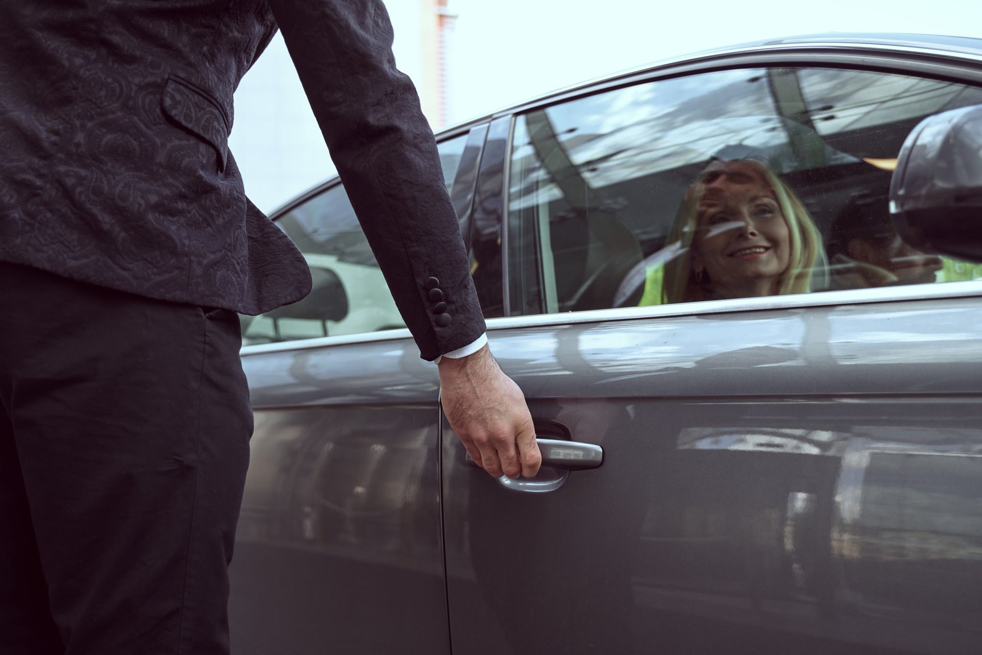 Un chauffeur de taxi qui ouvre la portière à une femme