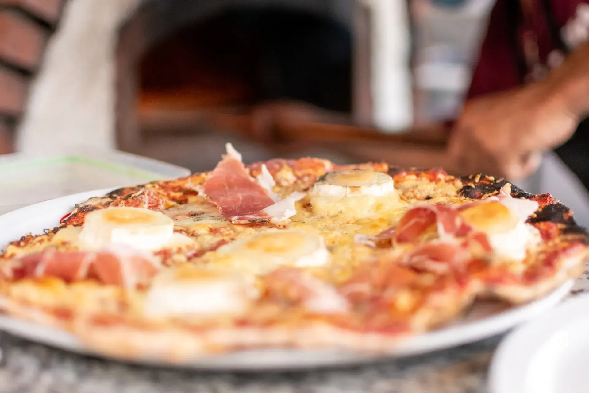 Pizza fromage et jambon cuisiné au four à bois